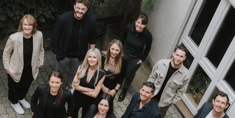 Gruppenfoto des Teams von oben vor dem Büro
